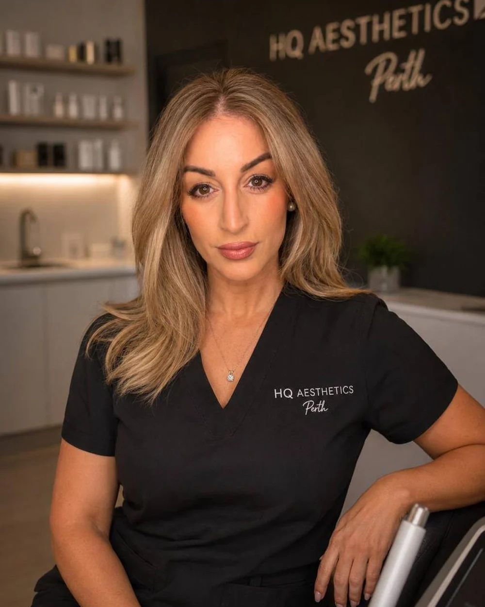 Simone in the treatment room at HQ Aesthetics in Melville, Perth, wearing her HQ Aesthetics scrubs
